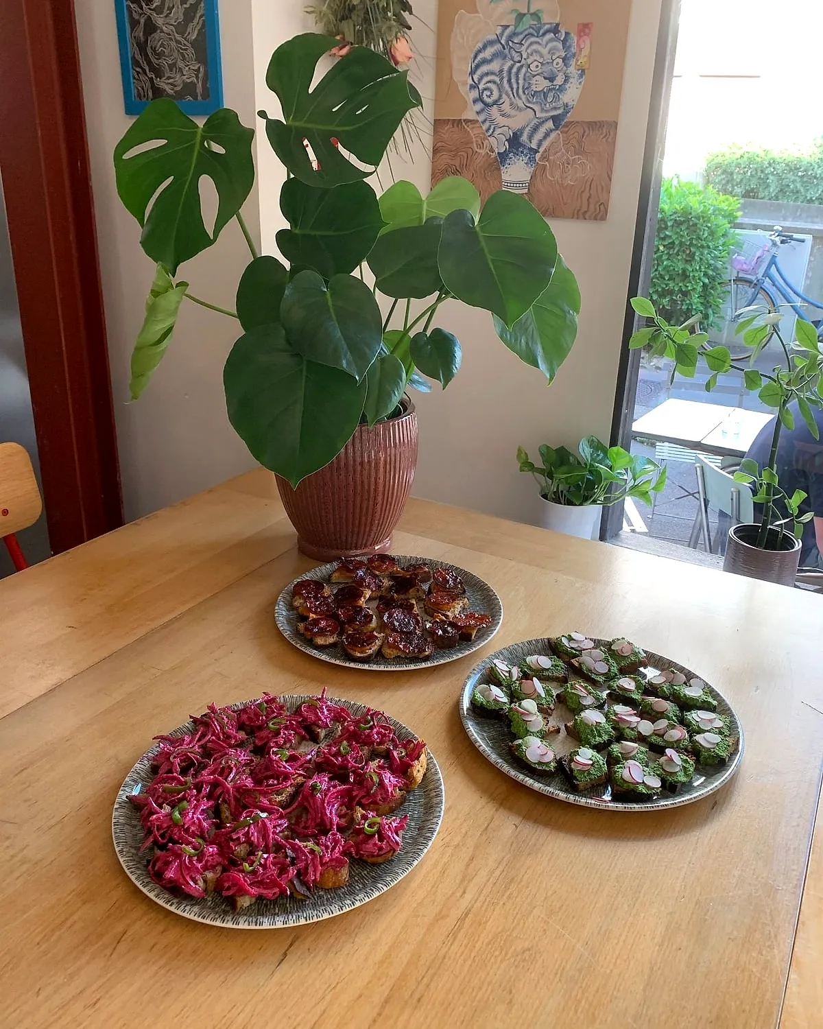 Assiettes à partager sur une table du Café, à côté d’une plante