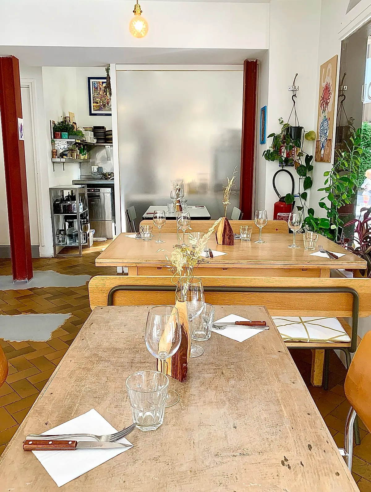 La salle du Café Perdu, tables en bois et plantes